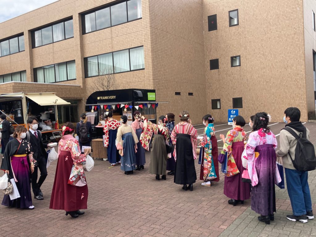 空き地に卒業生とキッチンカー